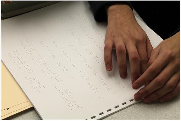 A person reading braille with their hands